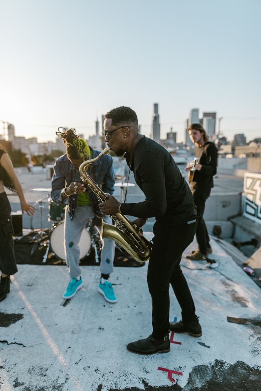 A saxophonist playing with a band on a rooftop